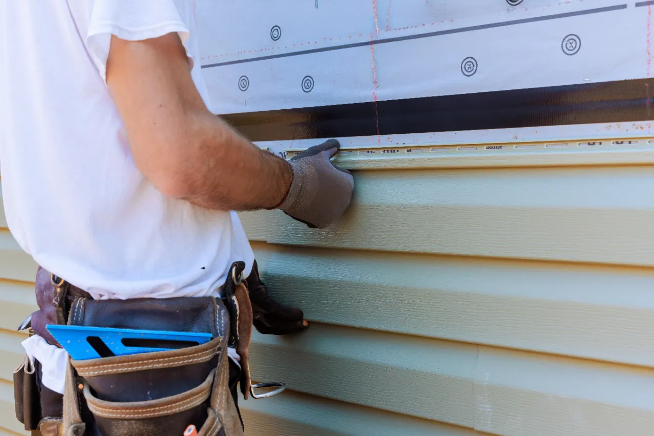 Worker installing siding on a house in New Jersey