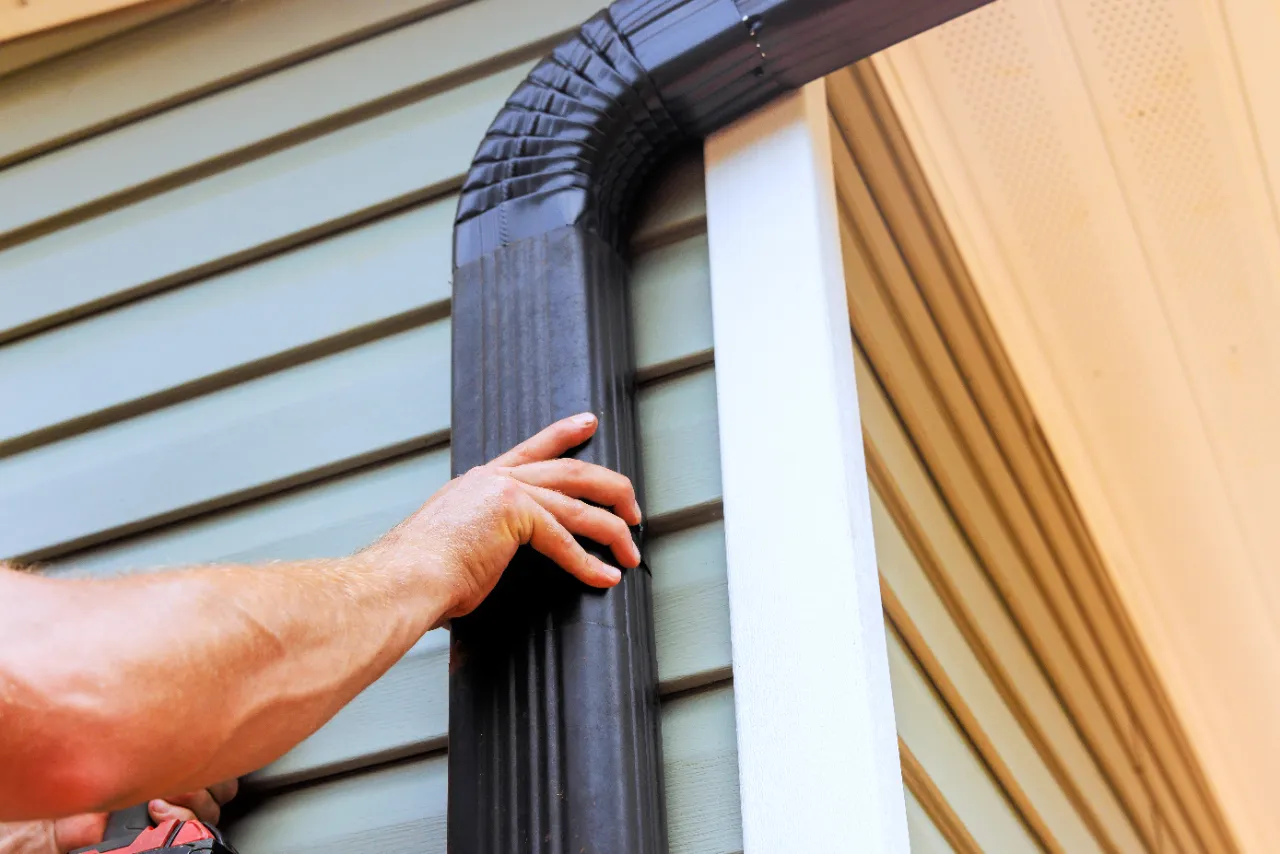 Worker installing rain gutter on a New Jersey home