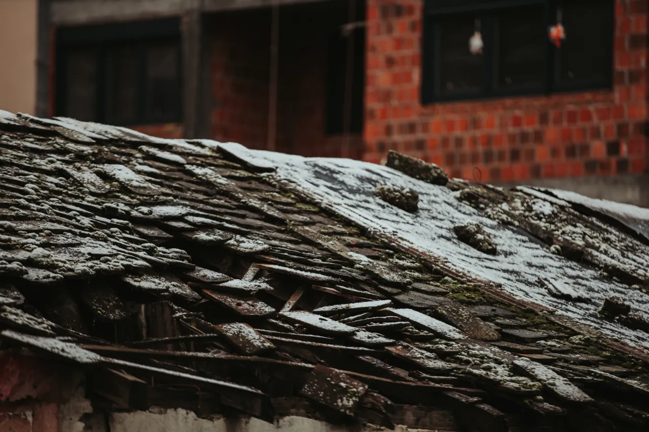 Old roof covered in snow showing winter wear in New Jersey