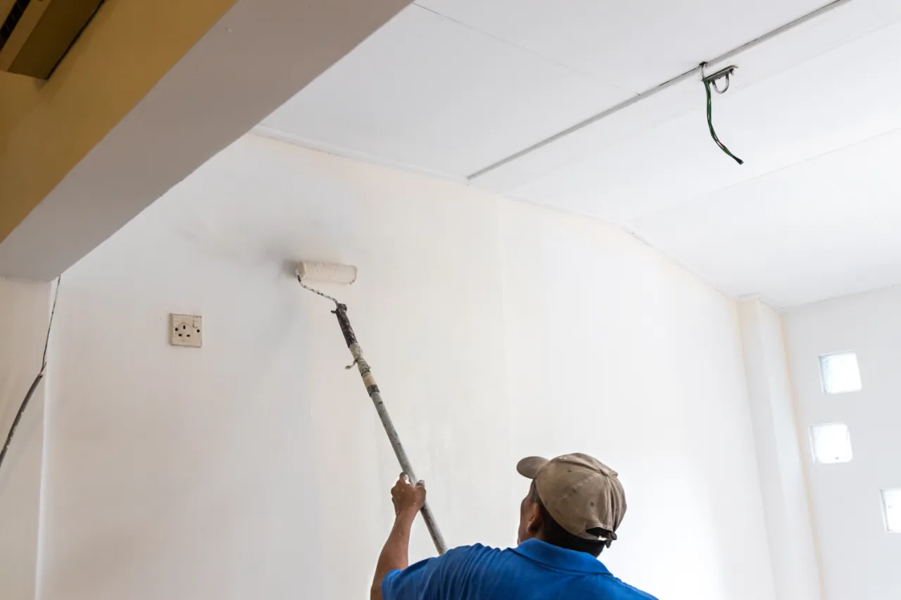 Painter painting interior walls in a bright New Jersey room